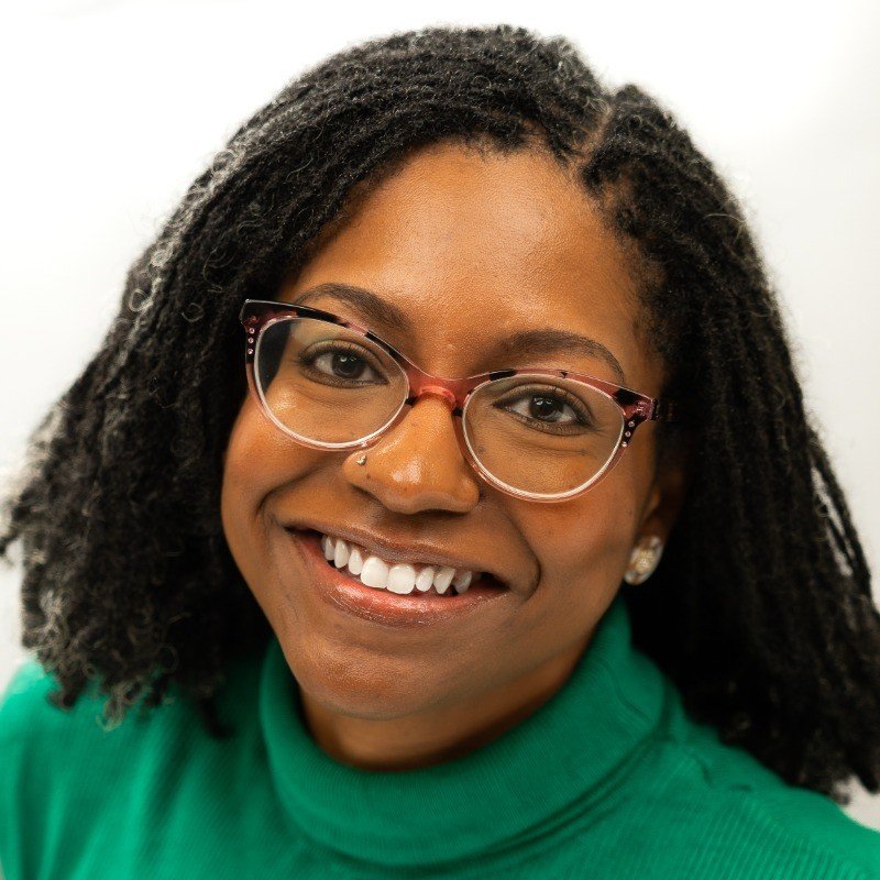 Raina Fields posing for a headshot against a white background.
