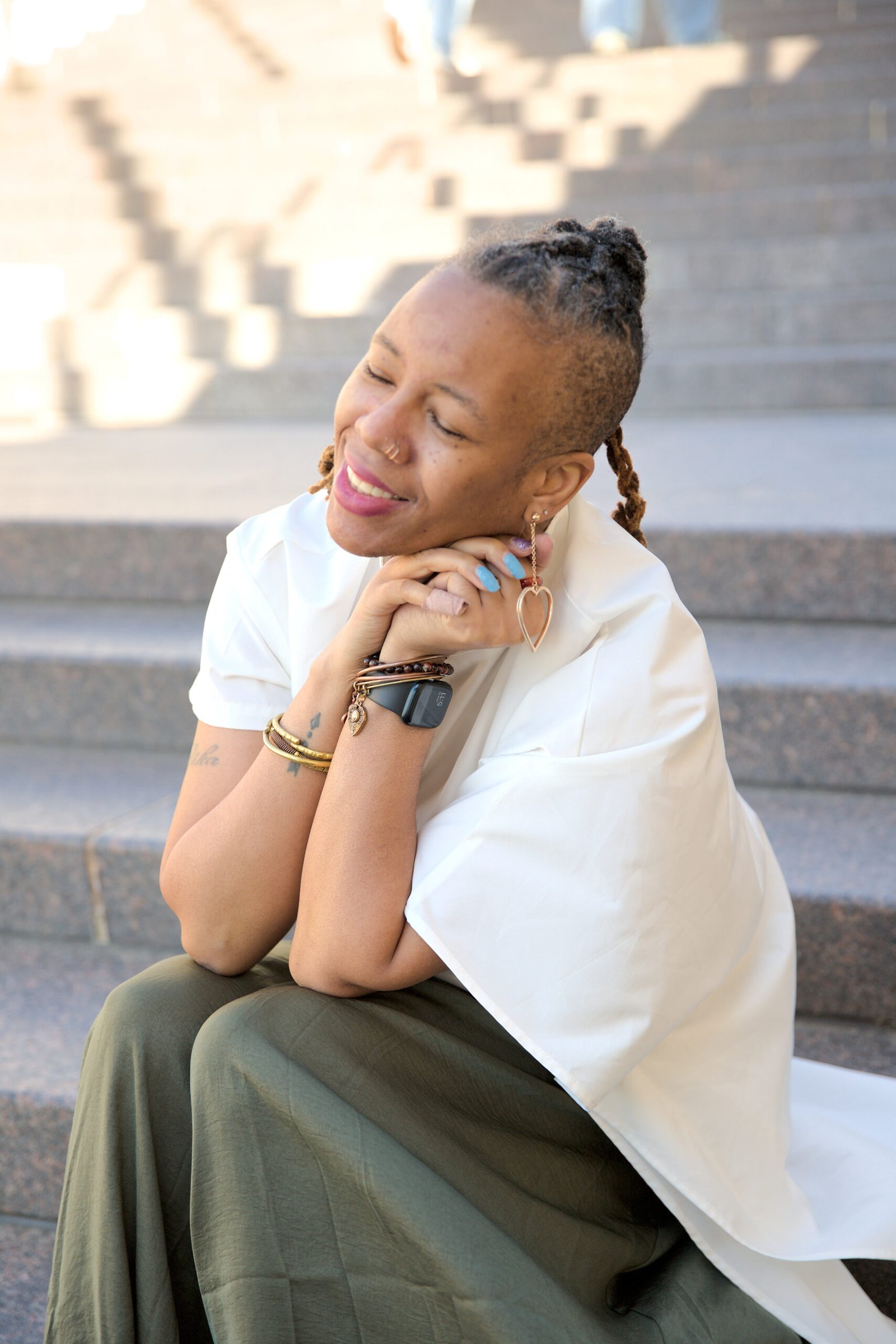 Min. Fredrika Sellers posing in a cream top and sage green pants, on the steps at the National Harbor in Maryland.